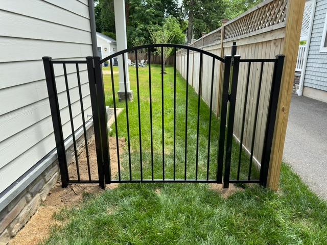 Black aluminum arched walk gate at a residential pathway — RKC Wood Care Pros