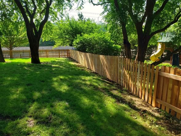 Cedar dog-ear picket privacy fence with galvanized ring-shank fastening in Grain Valley, MO — RKC Wood Care Pros