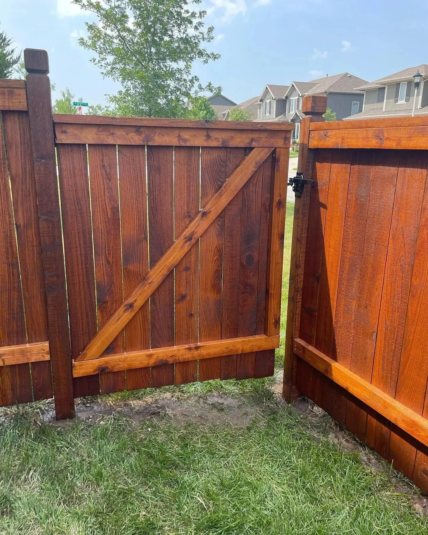 Dark walnut-stained cedar walk gate with diagonal cross-brace in the Kansas City metro — RKC Wood Care Pros