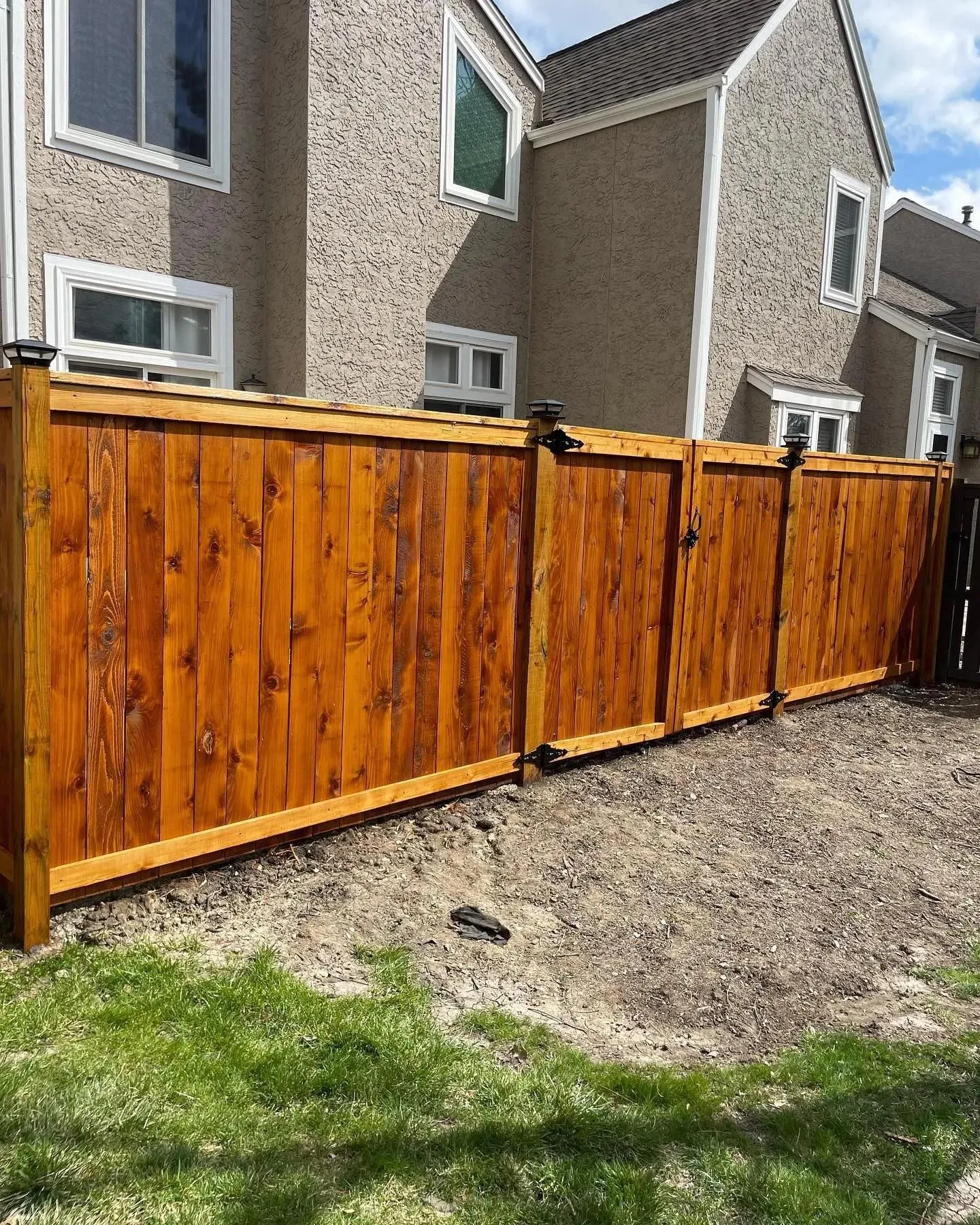 Semi-transparent stained cedar privacy fence with UV protective sealant in Olathe, KS — RKC Wood Care Pros