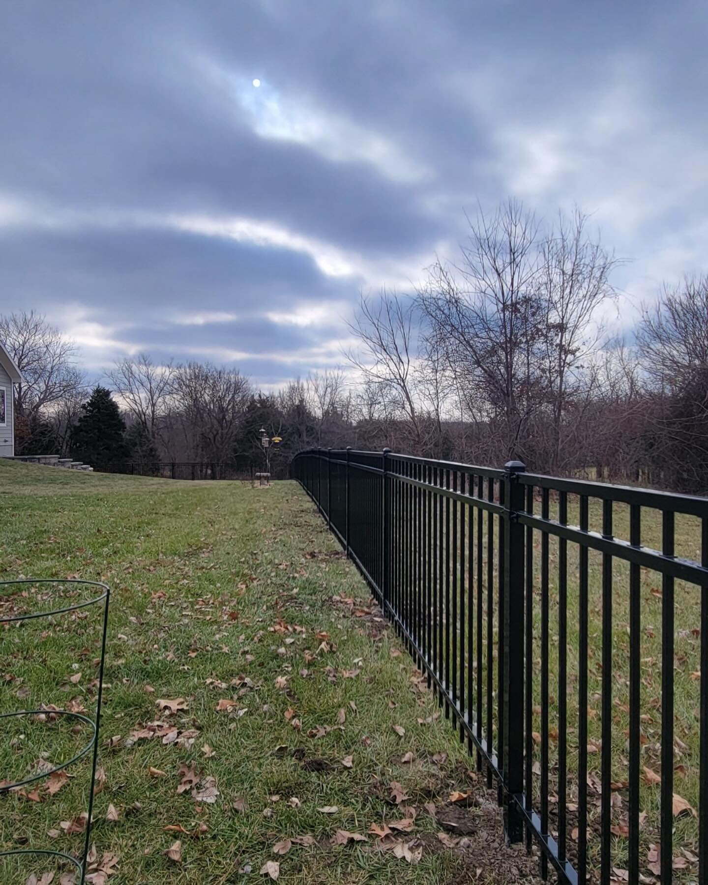 Black powder-coated ornamental iron fence with spear-top finials in a Kansas City front yard — RKC Wood Care Pros
