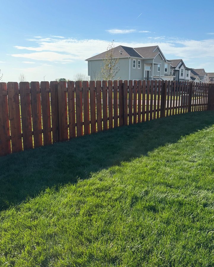 Dark-stained cedar shadow box fence with alternating pickets along a Kansas City property line — RKC Wood Care Pros