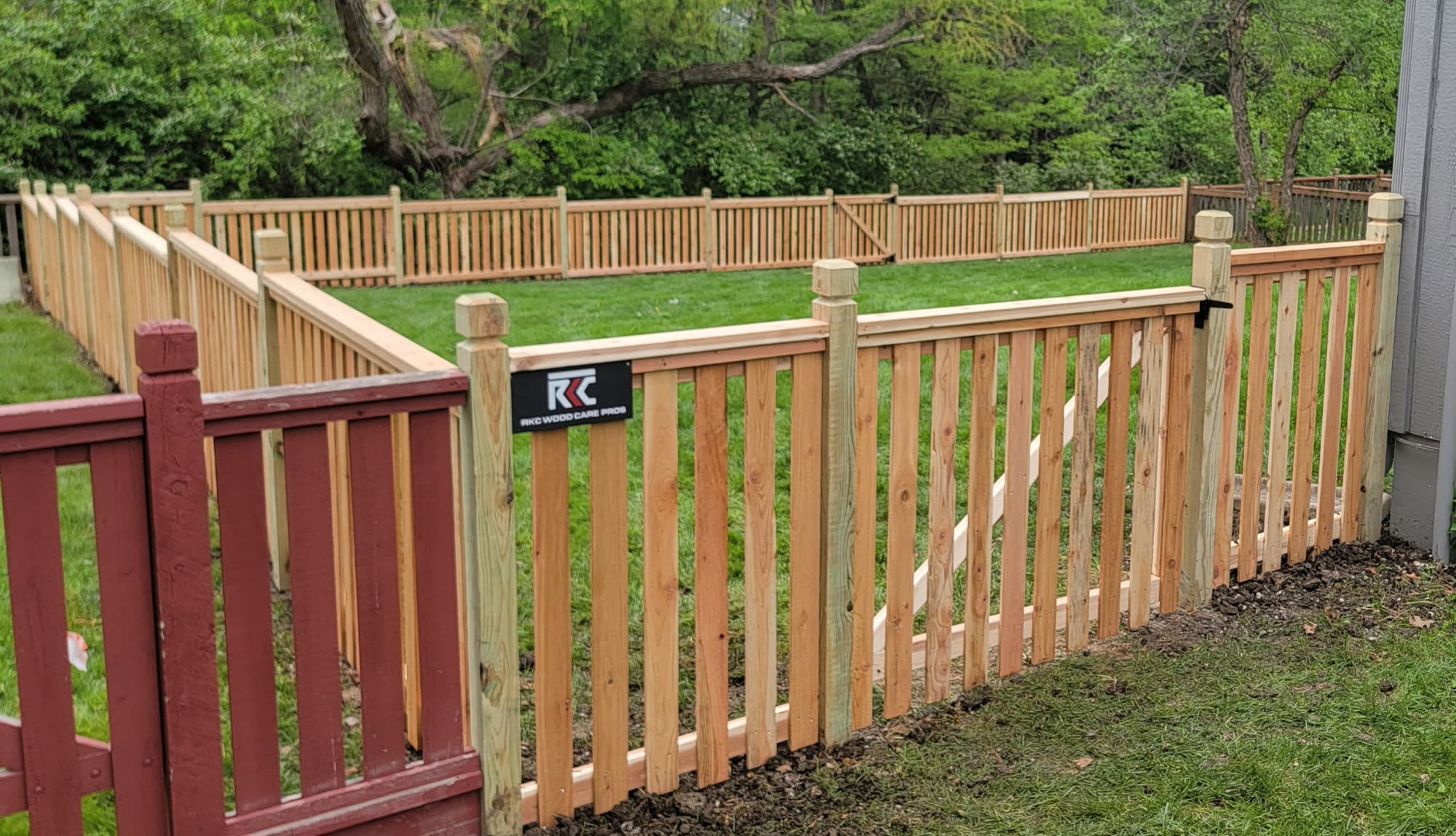 Cedar spaced picket fence with RKC sign in Lee's Summit, MO — RKC Wood Care Pros