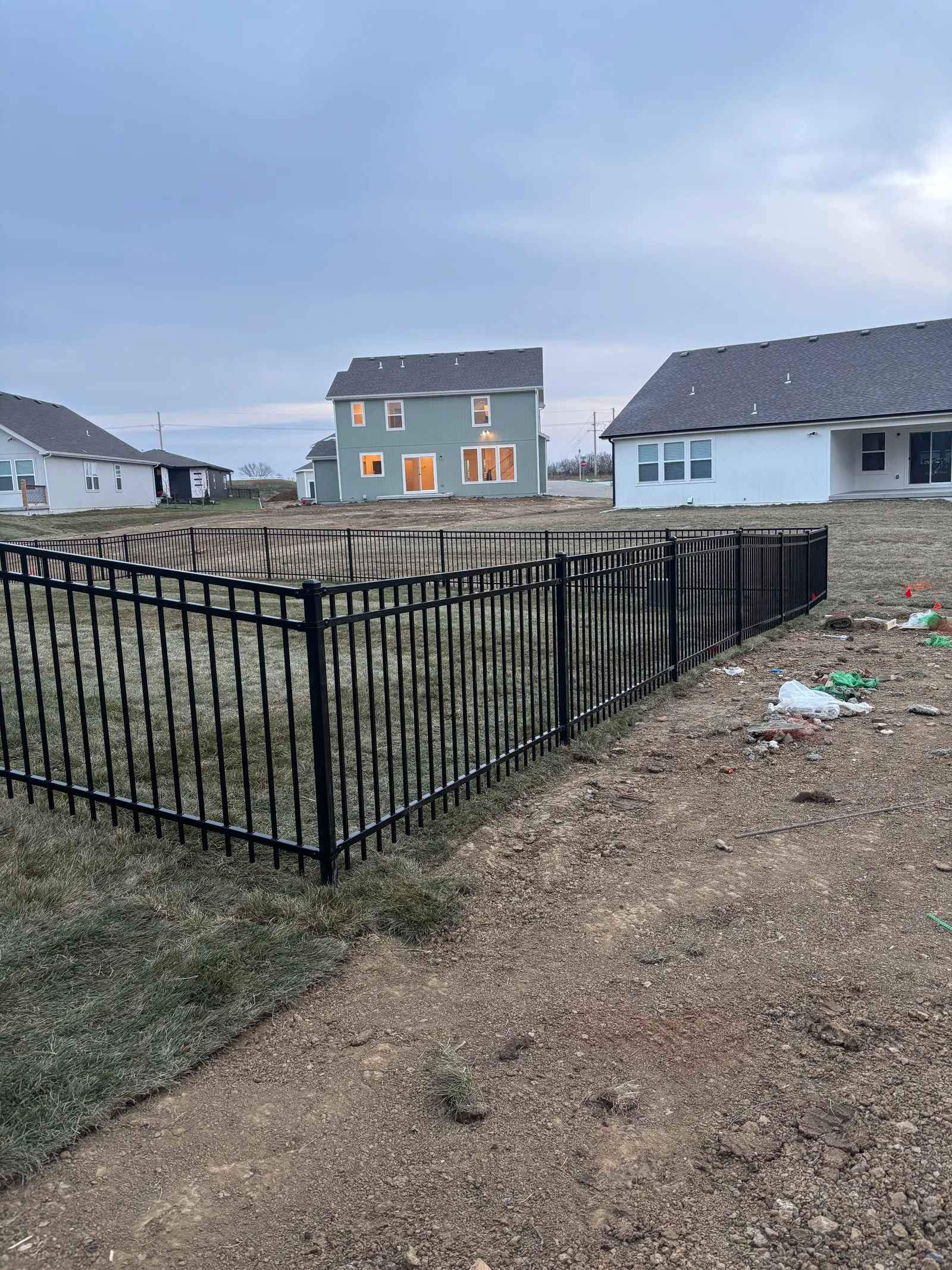 Heavy black iron ornamental fence installed on a new construction lot in Overland Park, KS