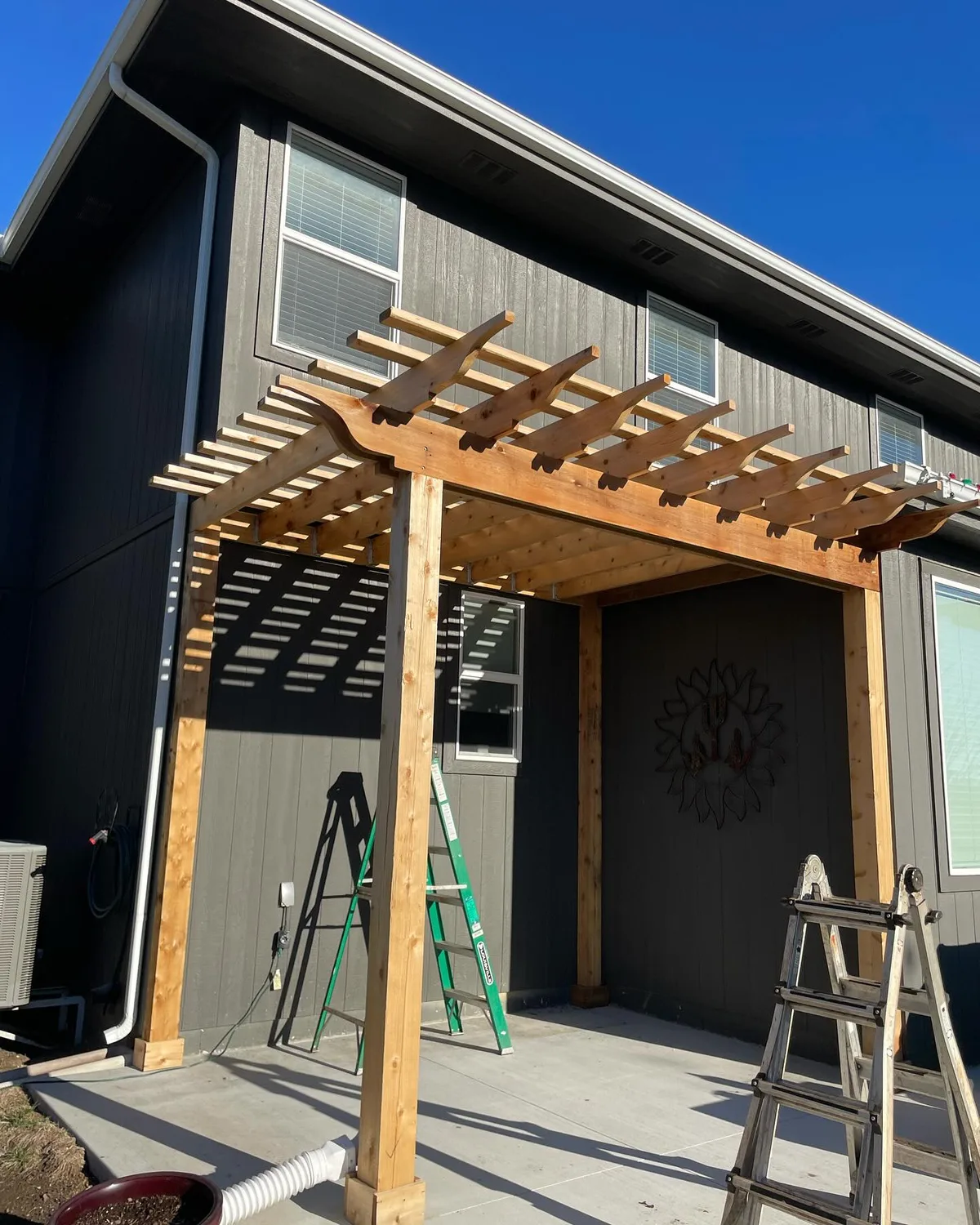 Side view of stained cedar pergola posts and overhead beams in Raytown, MO backyard