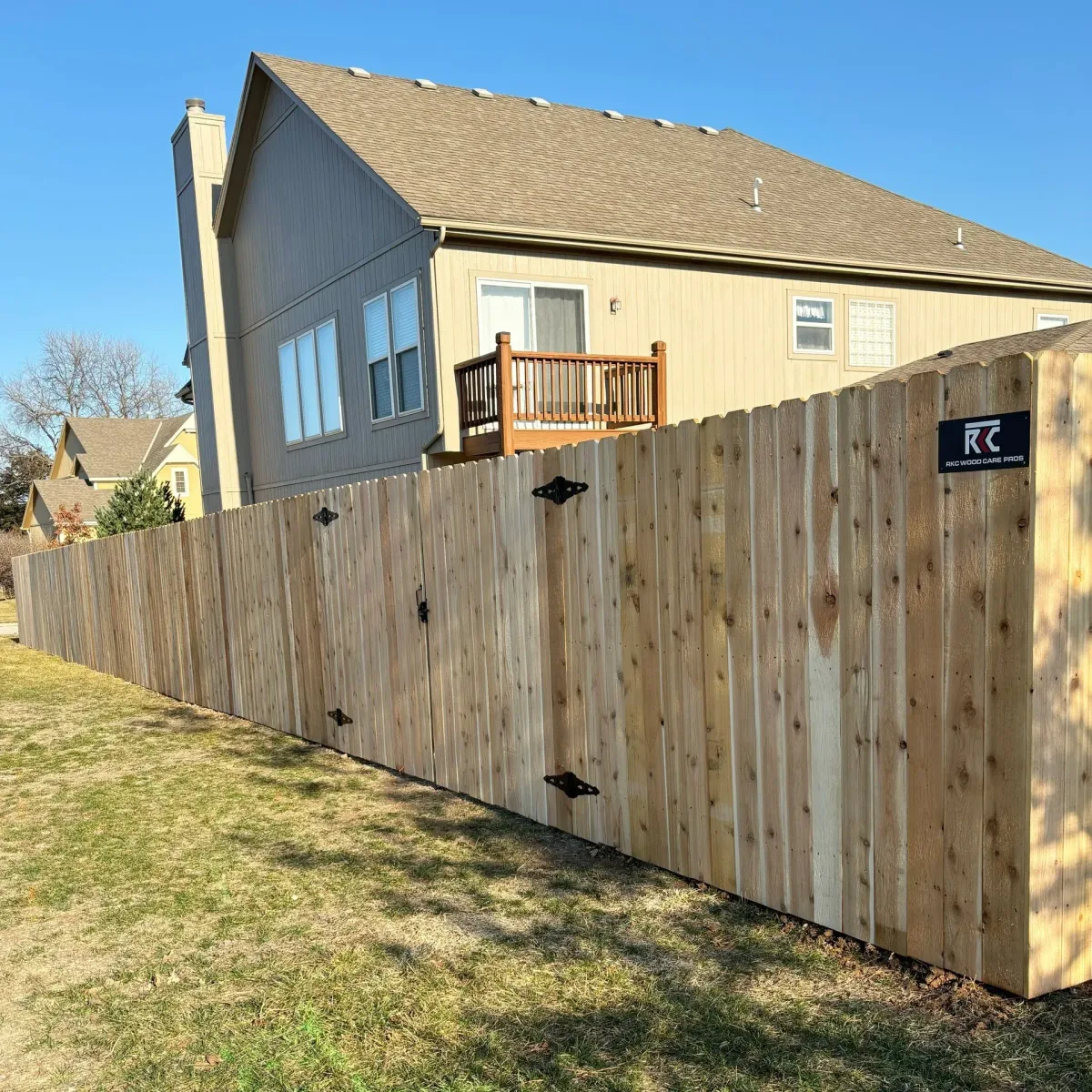 Far end view of cedar privacy fence with orange utility flag at base in Leawood, KS