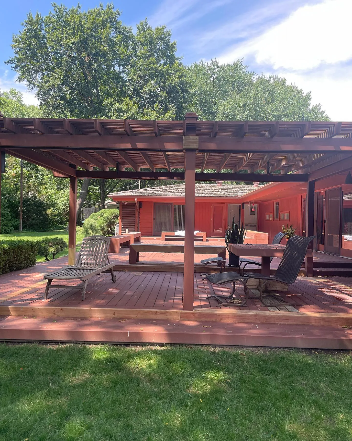 Large cedar deck and pergola freshly stained in rich warm tones in Liberty, MO — sunny summer day