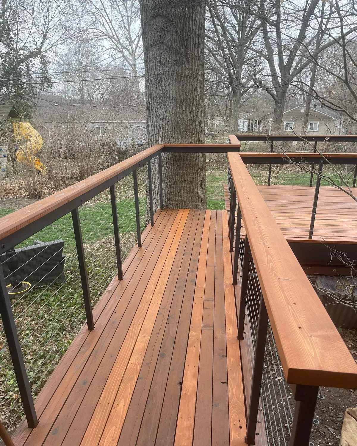 Cable railing and cedar deck corner detail after staining in Blue Springs, MO