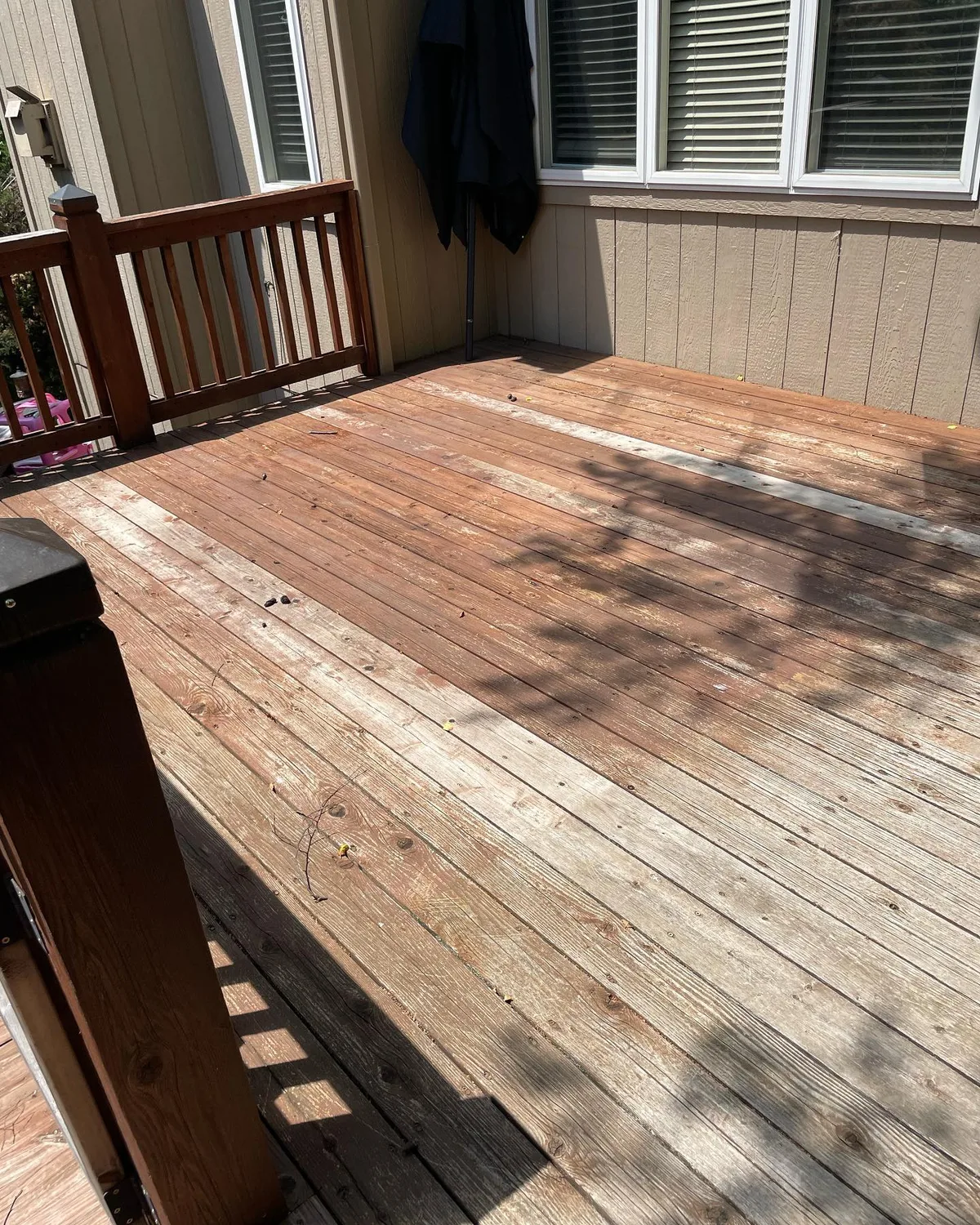 Deck and railing staining progress in Olathe, KS — boards mid-application