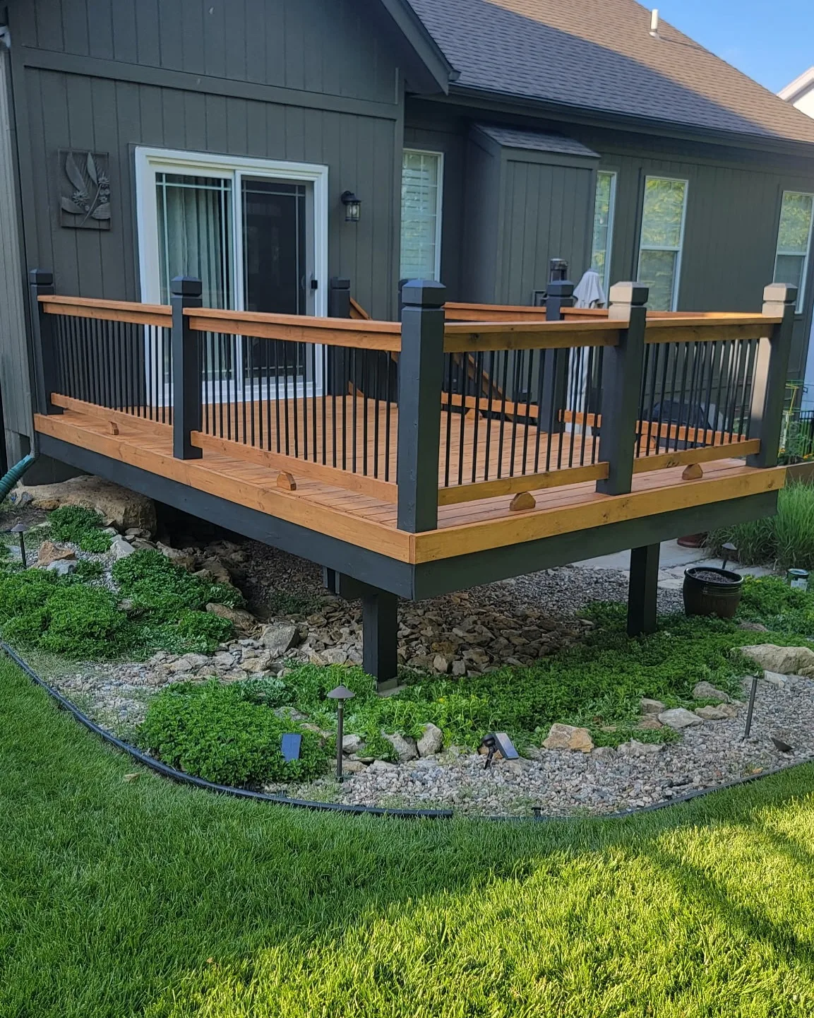 Stair tread and dark post railing detail of stained Mission, KS deck — two-tone finish