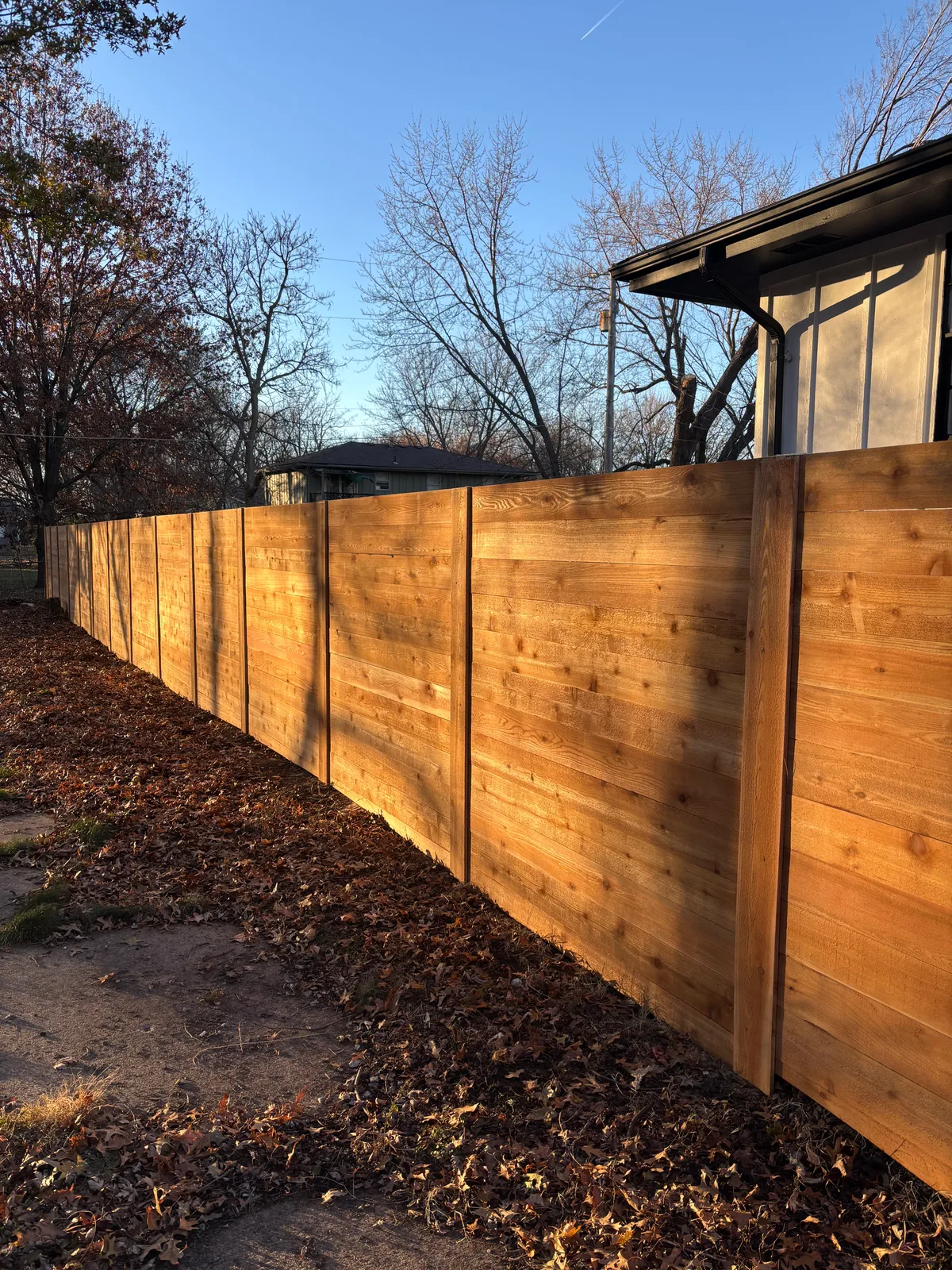 Same horizontal fence two years later in Smithville, MO — weathered to silver-gray before staining